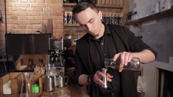 Barista making irish coffee. Pouring water into cups of whiskey.