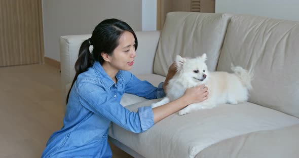 Woman Cuddle Her Pomeranian Dog at Home