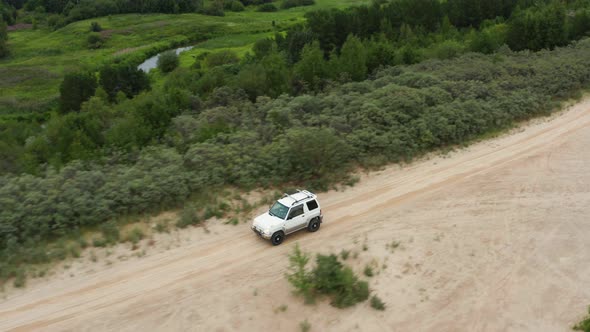 Aerial View of a Car Driving on Sand