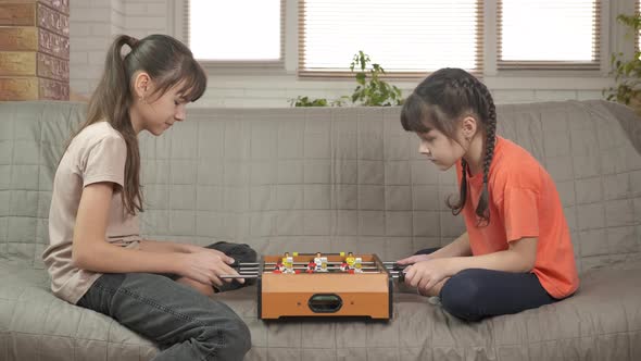 Sisters play table football. 