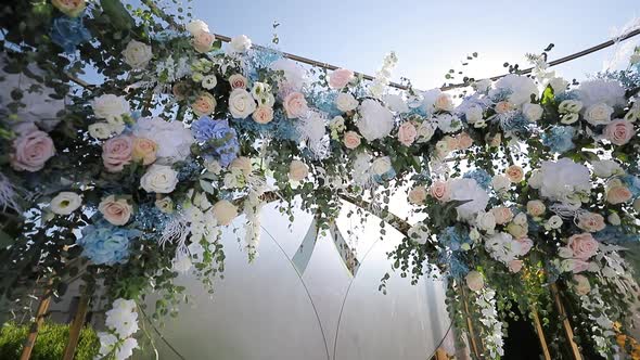 Wedding Arch With Fresh Flowers on Summer Sunny Wedding Day