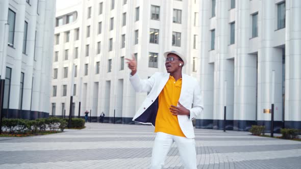 Black guy dancer in orange t shirt and white suit