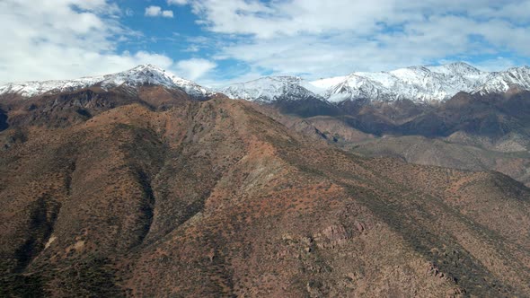 Aerial view truck left of San Carlos de Apoquindo Park, snowy mountain range in the background. Comm