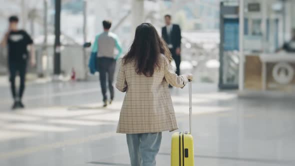 Silhouette of Young Woman Heading to Escalator to Platform