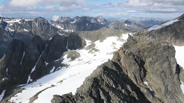 Panning drone footage of the amazing mountains and fjords of Kvaløya in northern Norway a july after