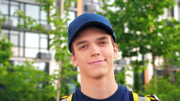 Close Up Smiling Young Man Courier Delivery with Thermal Backpack Looking Camera