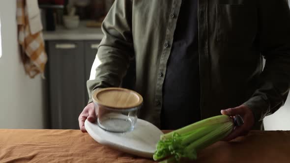 vegetarian man cuts Celery on a chalkboard in the kitchen with a knife