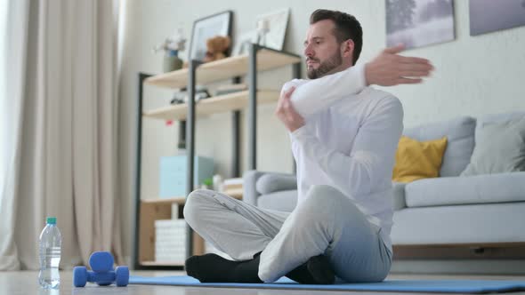 Man Doing Stretches on Yoga Mat at Home