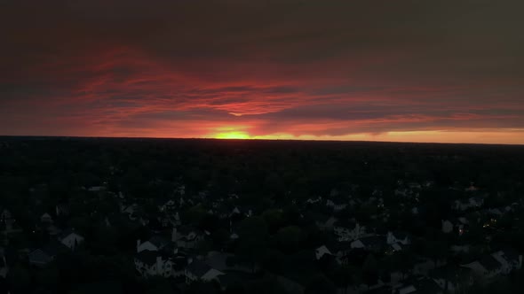 Aerial Wide View of Rainbow at Sunset Flying Over Neighborhood of Houses Before the Storm