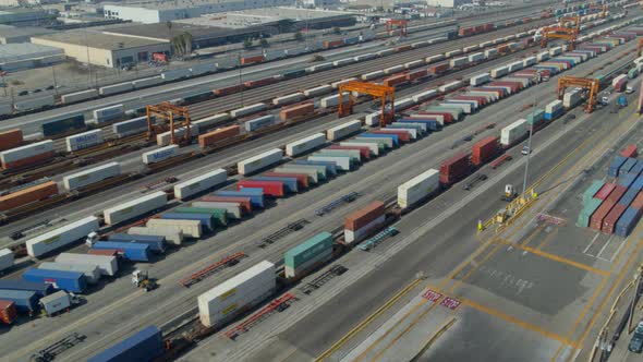 Aerial of cargo containers stored near railroad tracks in shipping yard