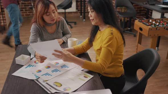 Colleagues Looking at Charts and Graphs on Documents