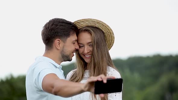 Couple Making Photo On Mobile Phone In Nature