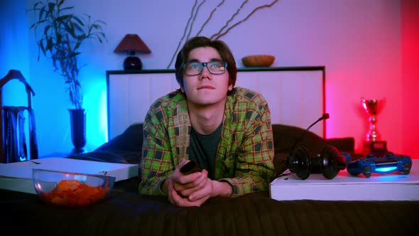 Young Handsome Man Lying on the Bed Watching TV