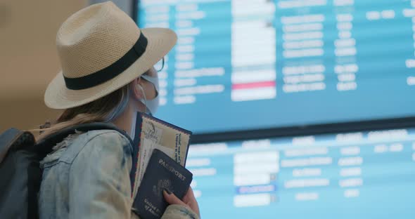 Woman Looking at Flight Timetable and Searching Flight in Airport Terminal