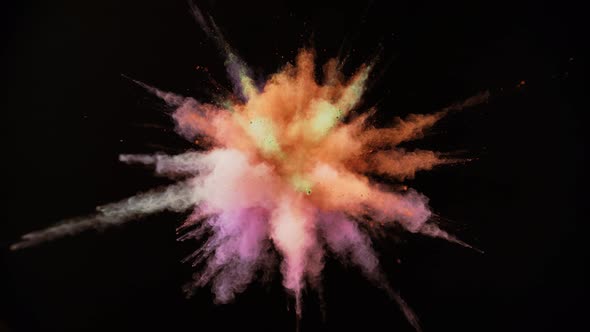 Colorful powder/particles fly after being exploded against black background. Slow Motion. alt
