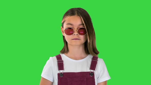 Asian Child in Sunglasses Walking on a Green Screen Chroma Key