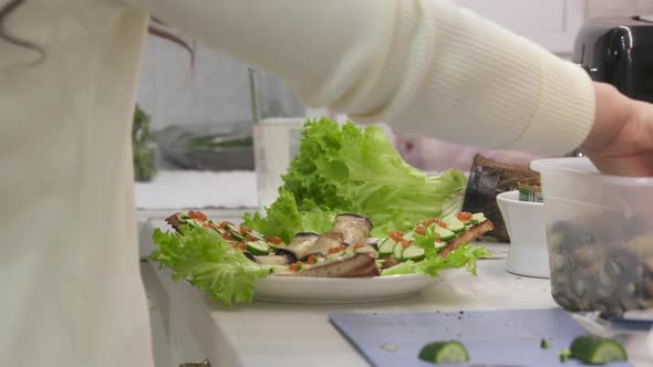 Woman Cooking Festive Dinner in the Kitchen Making Toast with Cucumber and Caviar