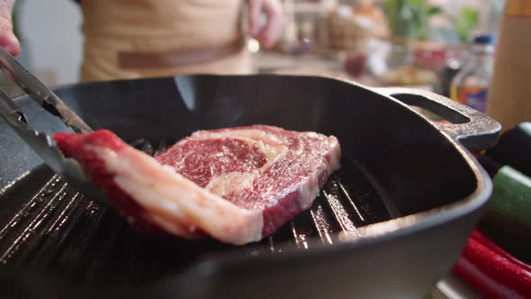 Male Chef Putting Meat Steak on Grill Pan