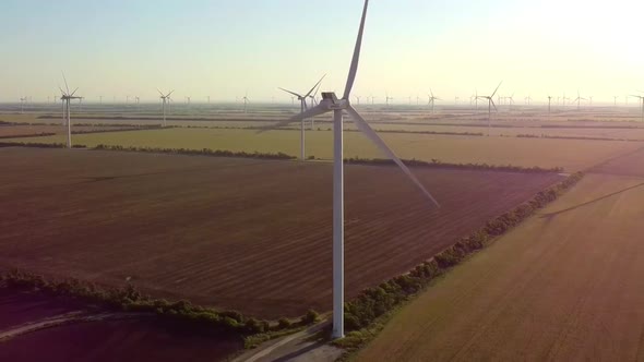 Windmills Produce Clean Electric Power in Field on Sunny Day