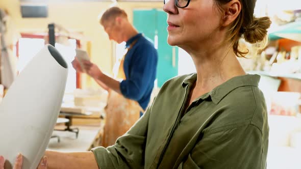 Male and female potter interacting while working 