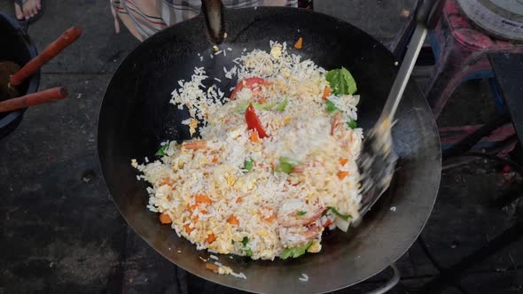 Stirring and Cooking Fried Rice with Vegetables in Wok at Open Air Kitchen - Overhead Medium Shot