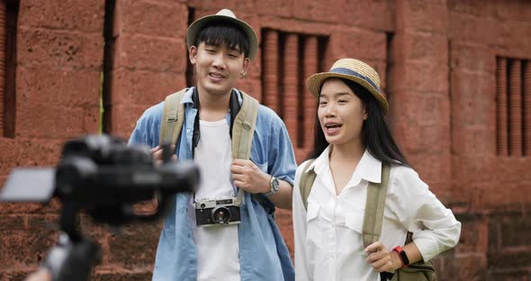 Couple videoblogger talking and looking at camera at ancient temple