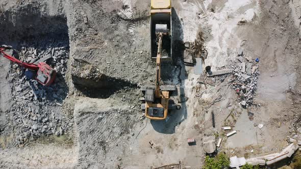 An Orange Crawl Excavator is Transfering Ground to the Loader