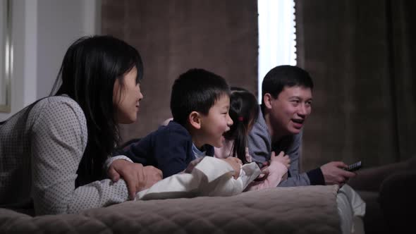 Joyful Asian Family with Kids Watching Film on TV