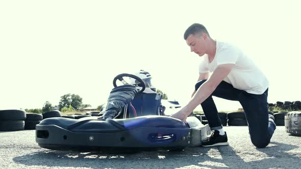 Attractive Man Checking Tire Pressure on His Gocart