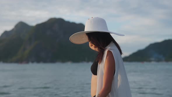 Woman In Bikini And Sunhat Walking In Sea