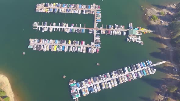 Aerial flyover of a small marina with docked boats at Shaver Lake in the California Sierra Nevada mo