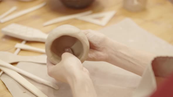 Hands of Anonymous Female Potter Forming Handmade Clay Vessel