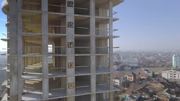 Aerial view of city residential area with high monolithic apartment building under construction