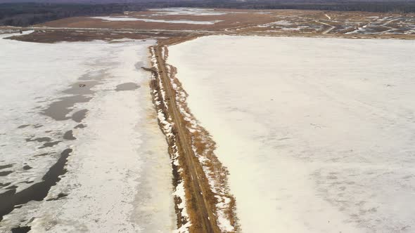 Aerial View Of Road Through Ponds In Winter Snowy Landscape