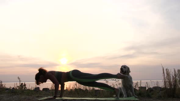 Sporty Female Doing Exercise at Sea Sunset