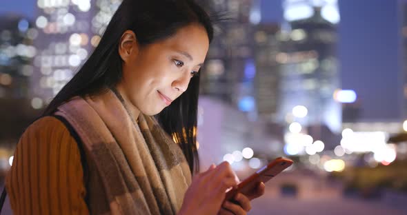 Woman Use of Smart Phone in Hong Kong City at Night