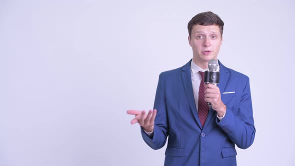 Young Handsome Businessman As Newscaster Presenting Something