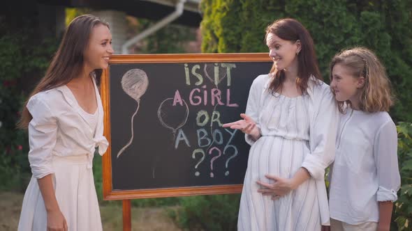 Curios Young Woman and Teenage Girl Waiting for Pregnant Friend to Tell Is It Boy or Girl at Baby