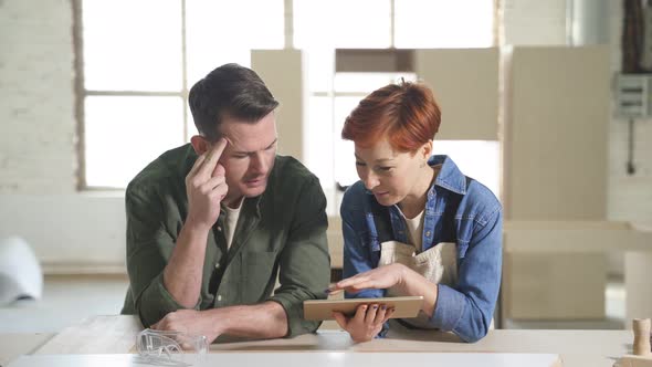 Pleasant Caucasian Colleagues Joiners Using Digital Tablet While Working in Workshop