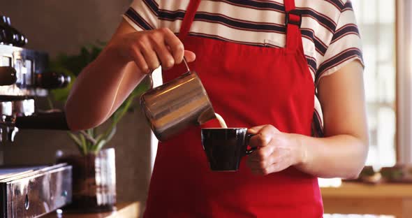 Waitress making cup of coffee at counter in caf������������