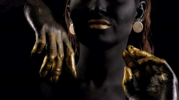 Art Portrait of a Young Female Model with Black Skin, Golden Lips, Hands, Eyes.
