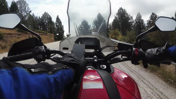 POV Biker on Motorcycle Rides on High Mountain Pass in Cloudy Weather with Fog