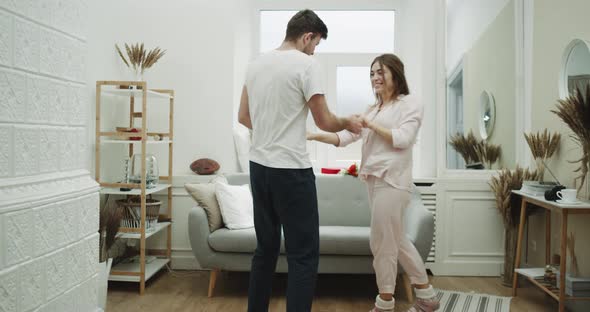 Happy Couple in Pajamas Dacing in Their Cozy