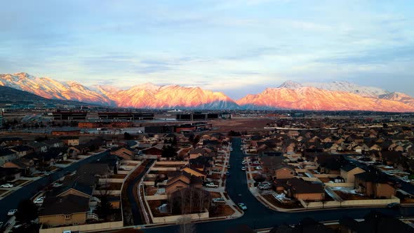 Silicon Slopes in Lehi, Utah with the sunset glowing on the snowy mountains - sliding aerial view