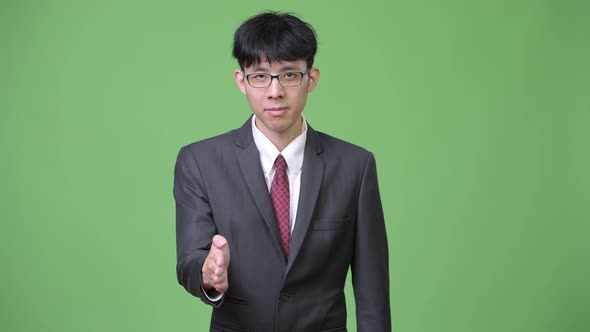 Young Asian Businessman Giving Handshake
