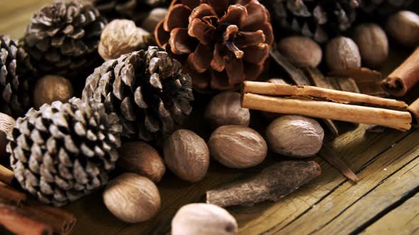 Pine cones and cinnamon sticks on wooden table 4k