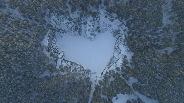 Flooded heart-like talc quarry "Talc stone" in forest near the Sysert city. Aerial, winter. 03