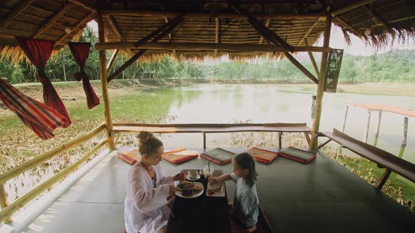 The Happy Family Eat and Drink Tasty Beverages Spending Time in Local Floating Cafe on Water