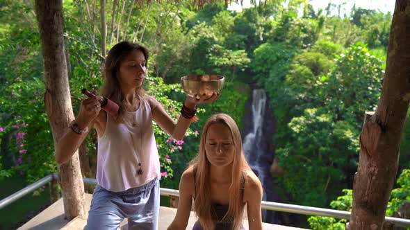 Superslowmotion Shot of a Woman Master of Asian Sacred Medicine Performs Tibetan Bowls Healing