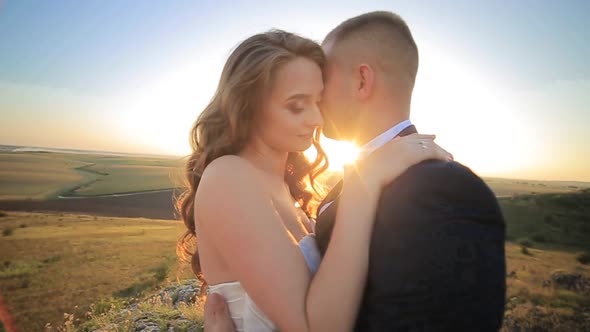 Beautiful Wedding Couple Kiss on the Sunset in the Mountains